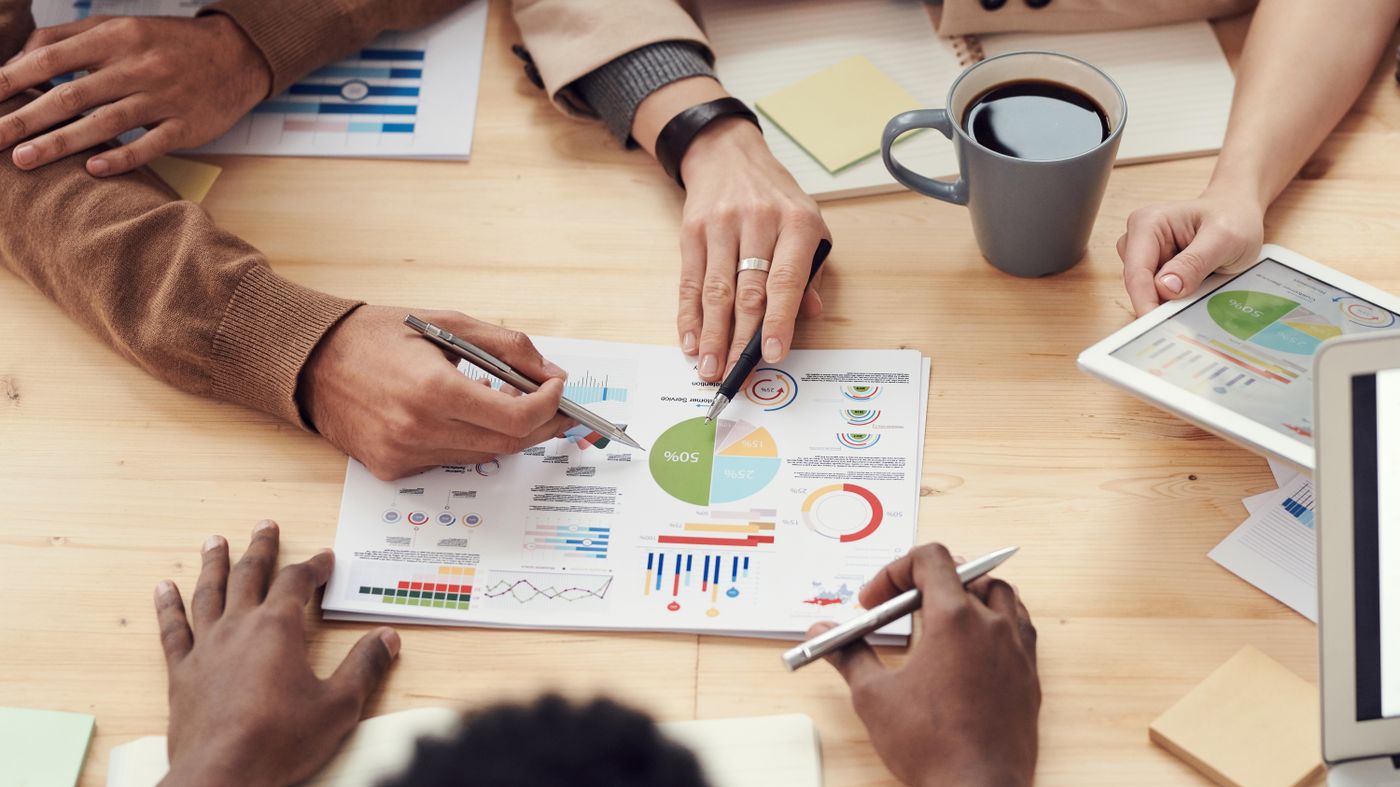 Hands reviewing charts and investment planning documents
