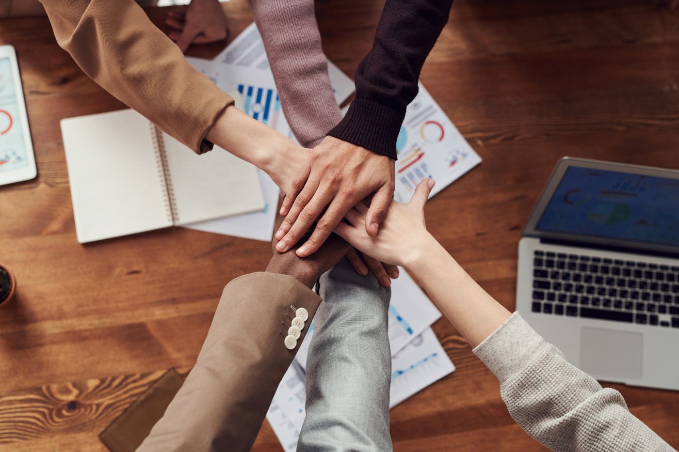 Hands joined above professional planning documents